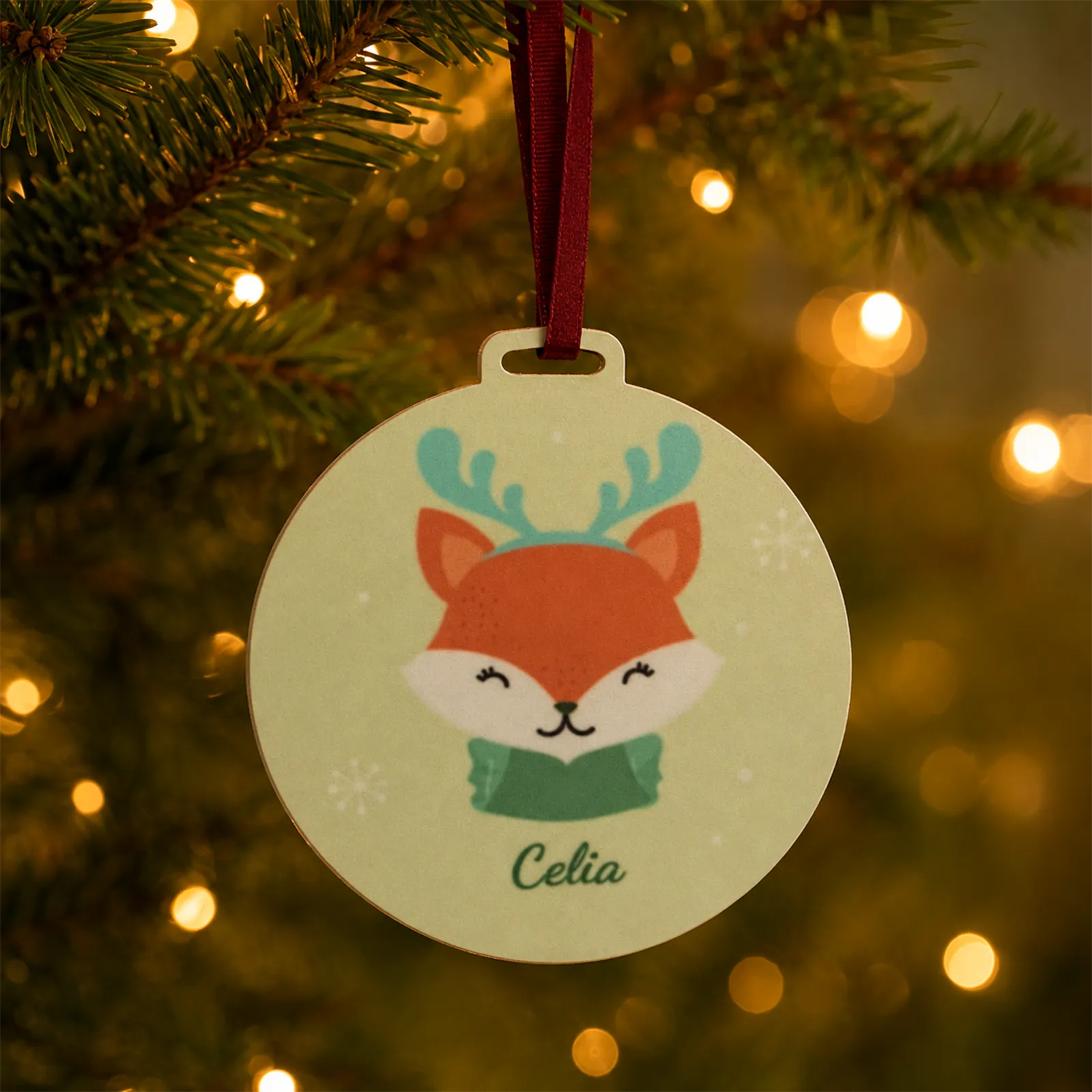 Adorno navideño personalizado con zorrito y nombre Celia, colgado en el árbol de Navidad.