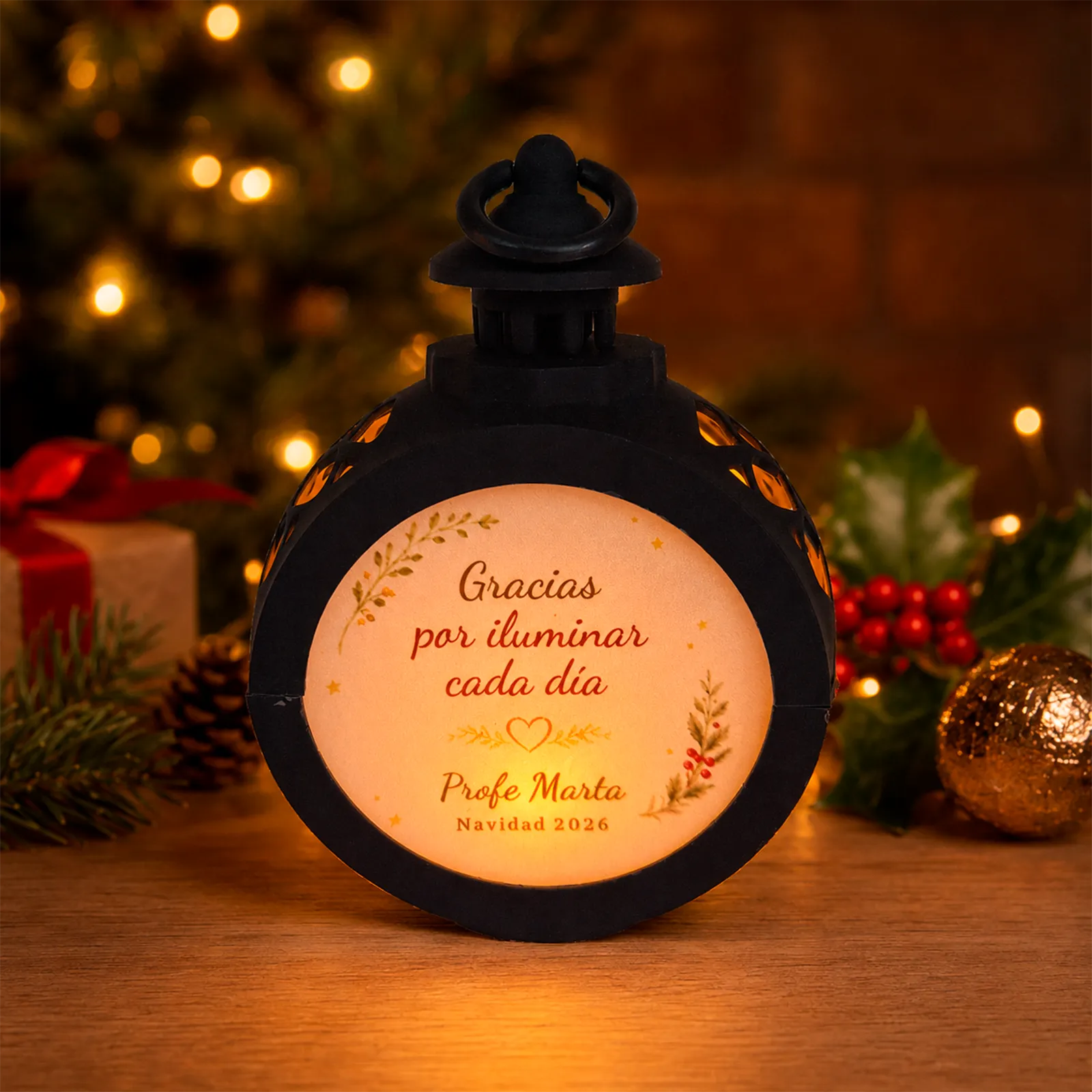 Farolillo LED redondo negro personalizado para una profesora con la frase «Gracias por iluminar cada día», encendido en un ambiente navideño.
