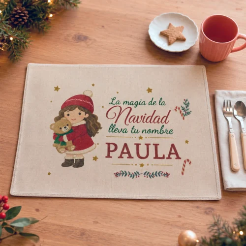 Salvamantel navideño personalizado con niña, osito y nombre Paula en una mesa decorada.