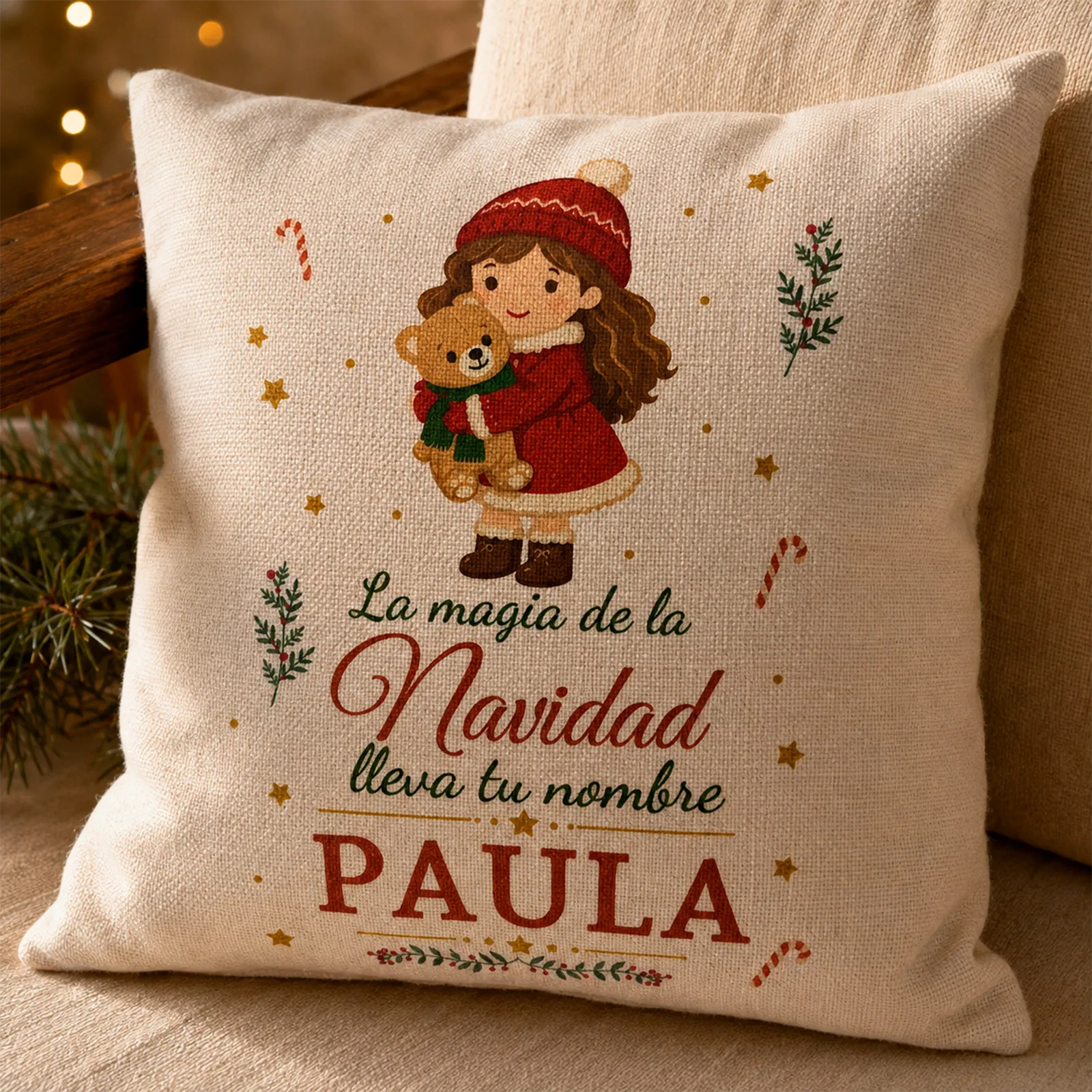 Detalle del cojín navideño personalizado con nombre y niña abrazando un osito
